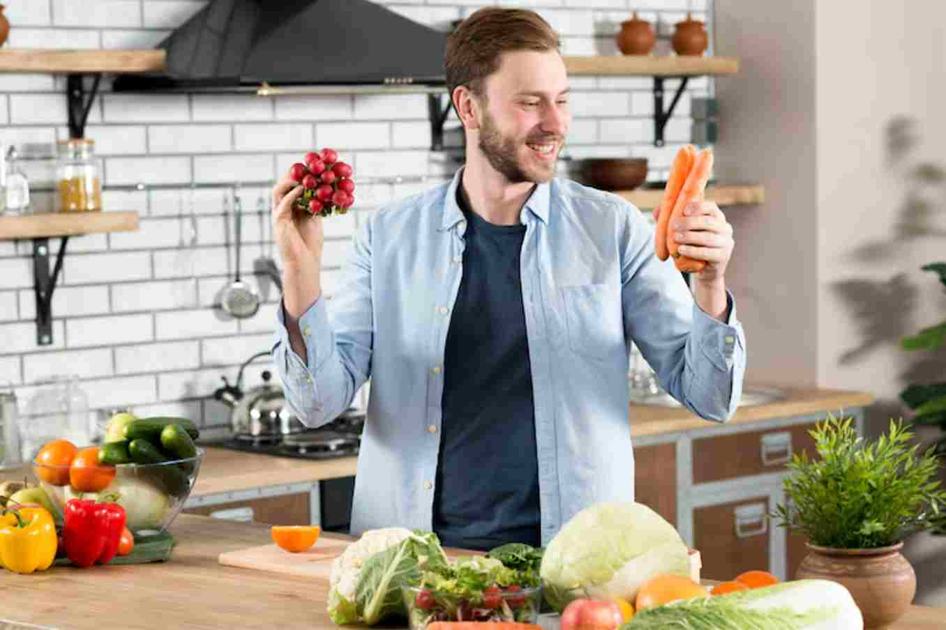 Smiling man holding fresh vegetables in kitchen