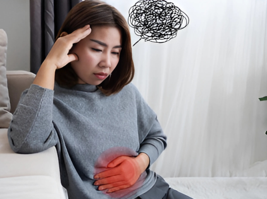 Woman holding stomach, showing discomfort and stress.