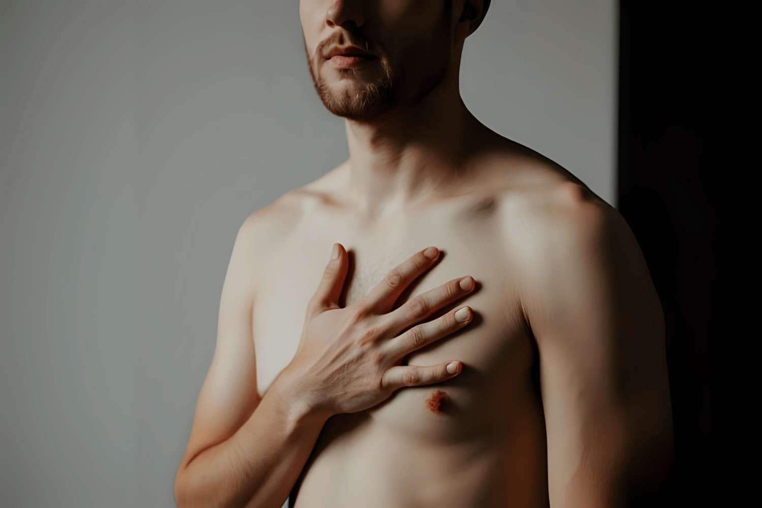 Man holding chest with a concerned expression